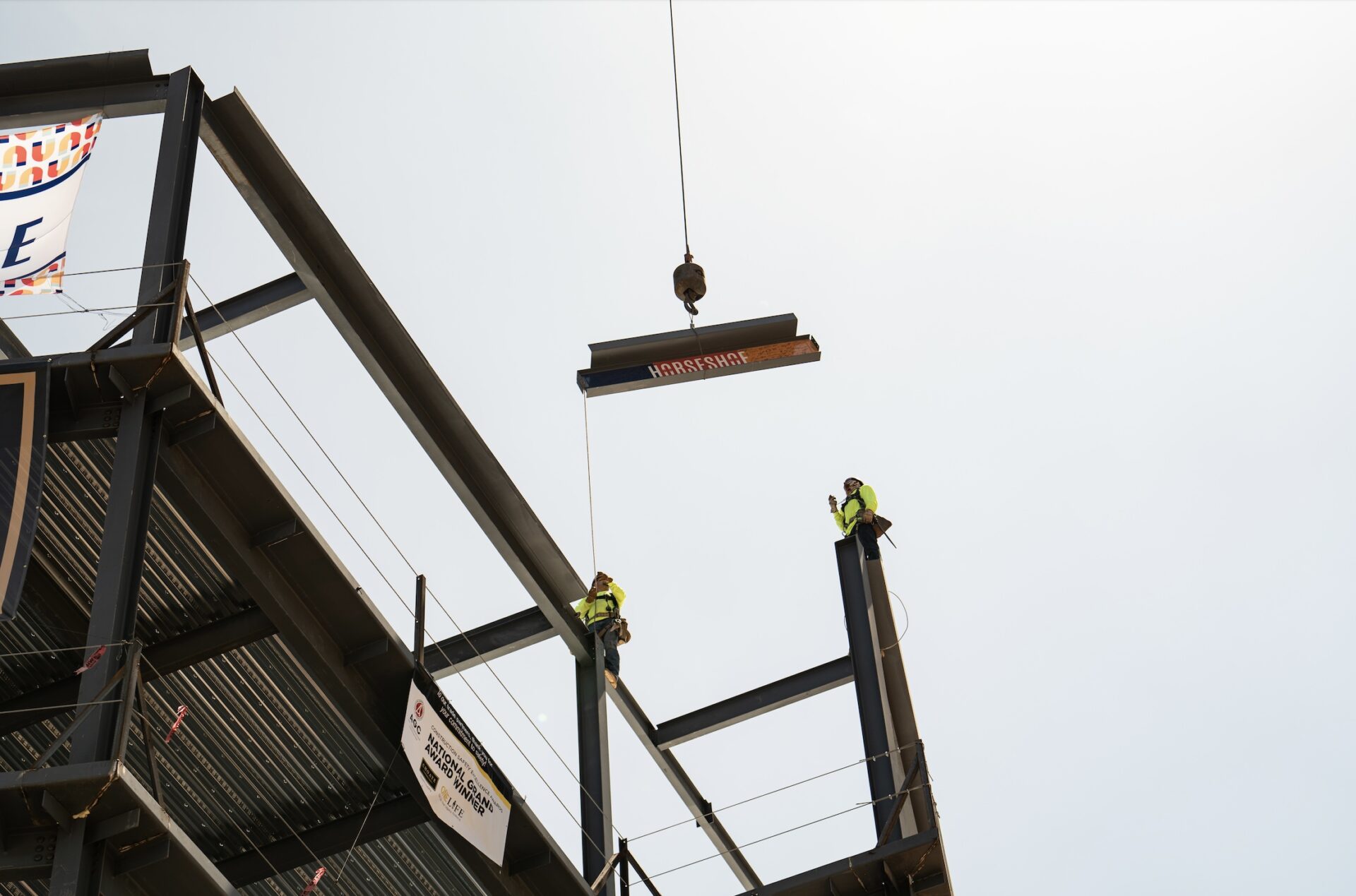Construction worker harnessed, installing the last steel beam at Horseshoe